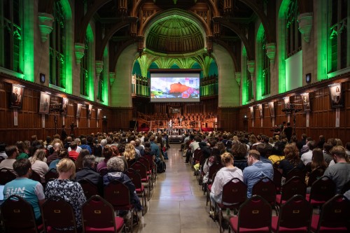 People sitting in a hall facing a stage
